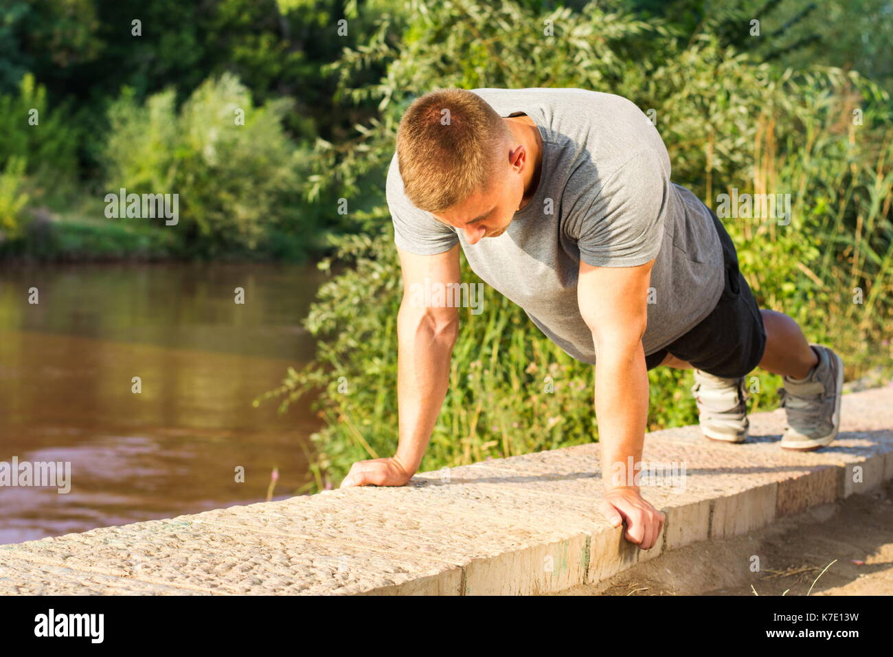 Mann, die Push-ups durch den Fluss Stockfoto