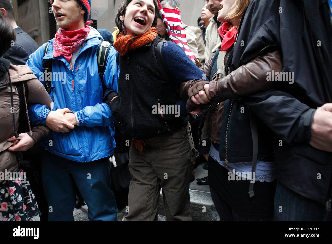 Demonstranten link Arme eine Menschenkette während der Besetzt die Wall Street März an der Wall Street in New York am 17. November 2011 zu bilden. Stockfoto