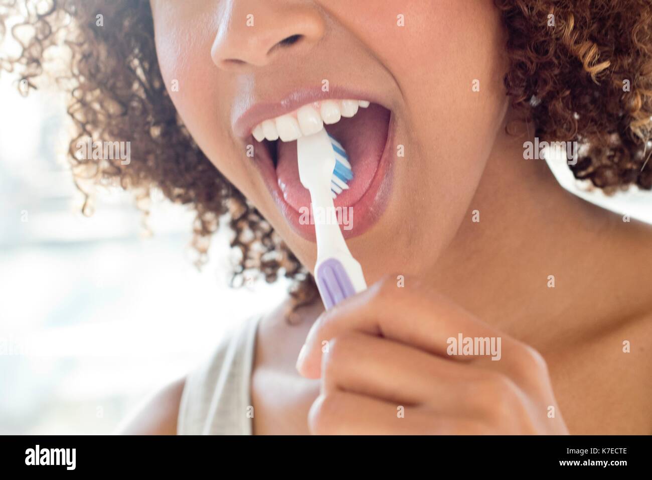 Portrait von Mitte der erwachsenen Frau putzen Zunge. Stockfoto