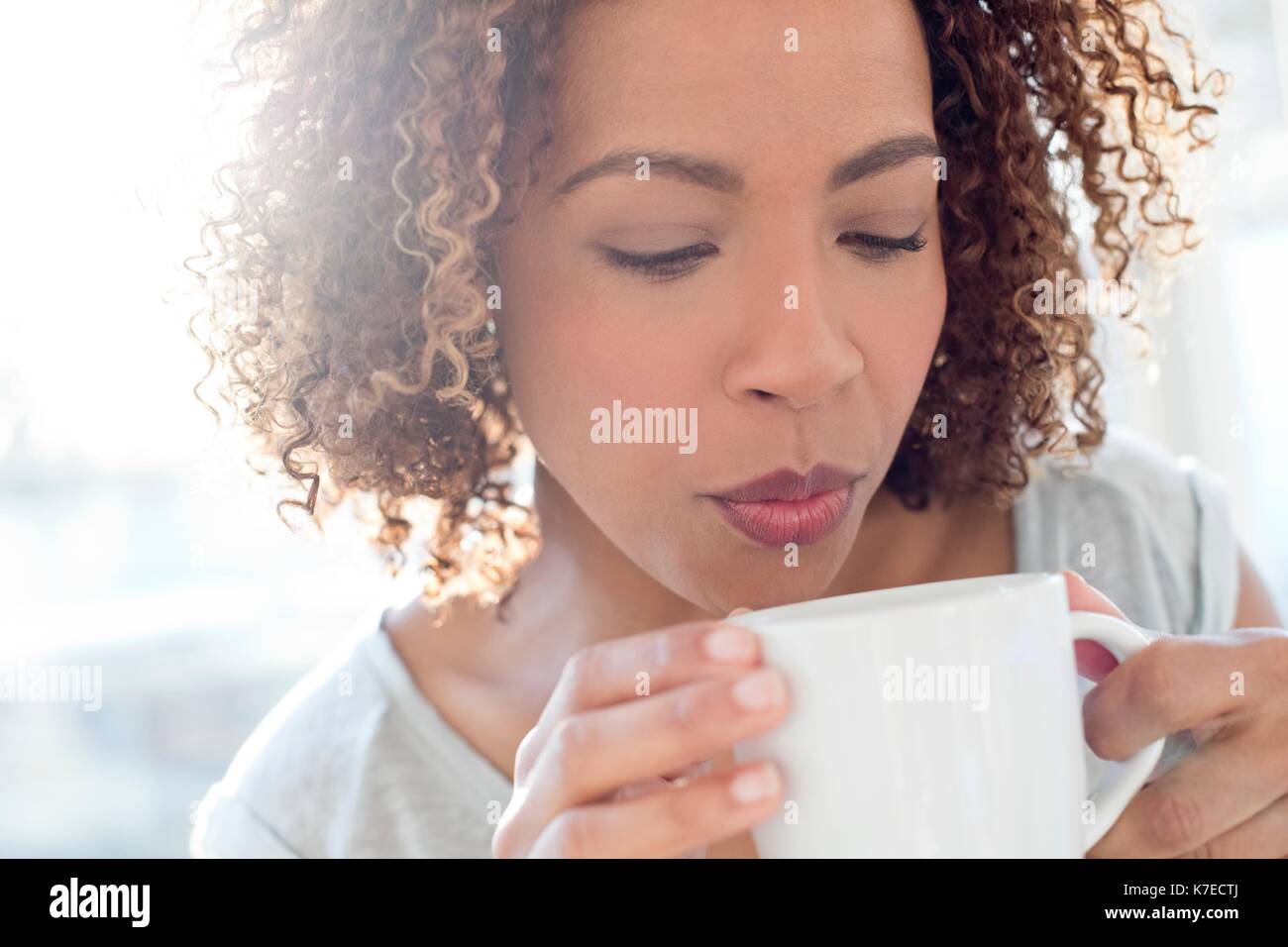 Mitte der erwachsenen Frau Blasen auf Kaffee. Stockfoto