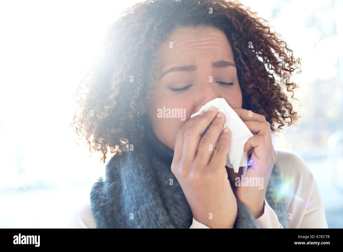 Mitte der erwachsenen Frau blasen Nase auf Gewebe. Stockfoto