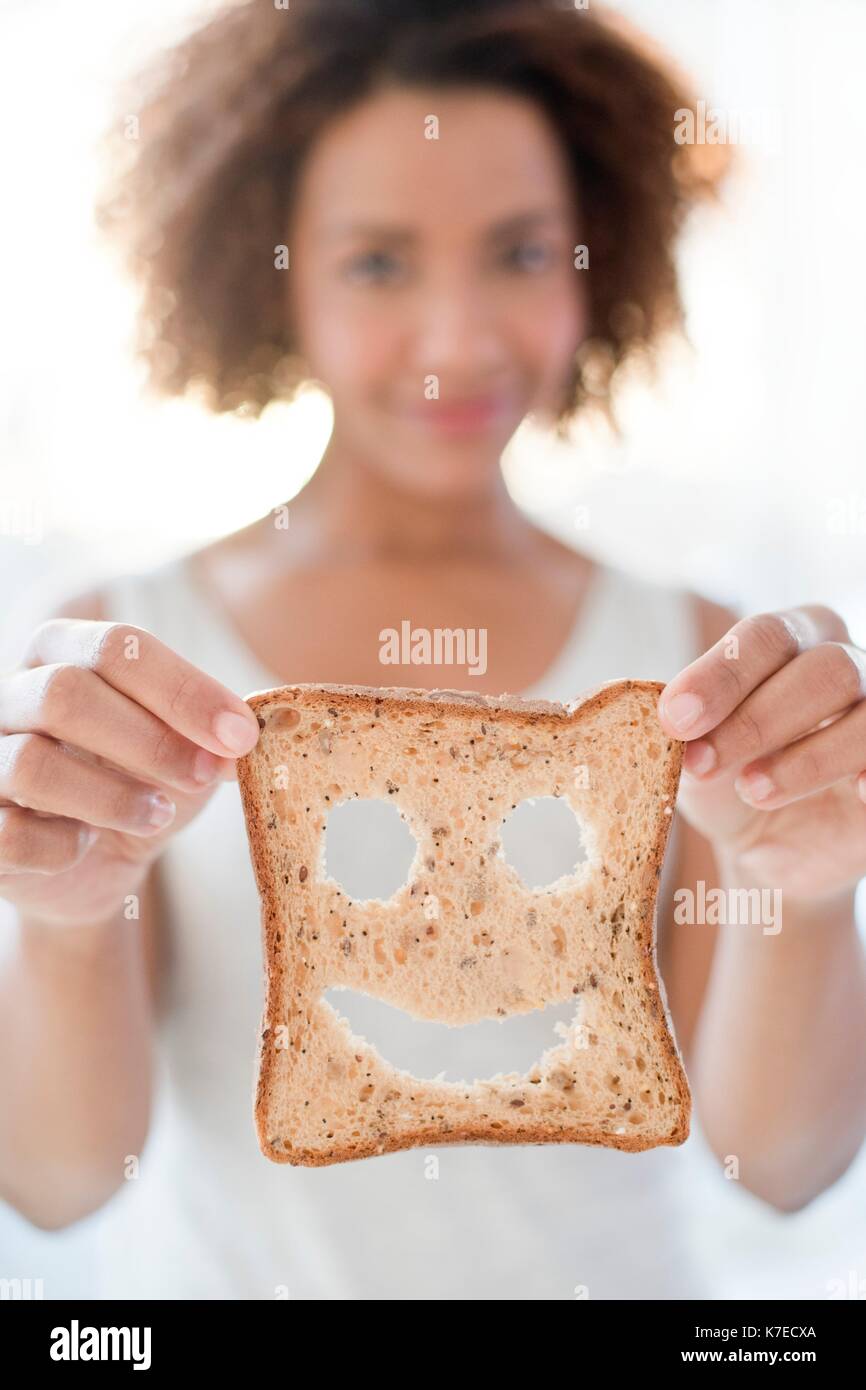 Mitte der erwachsenen Frau mit Brot mit Smiley. Stockfoto
