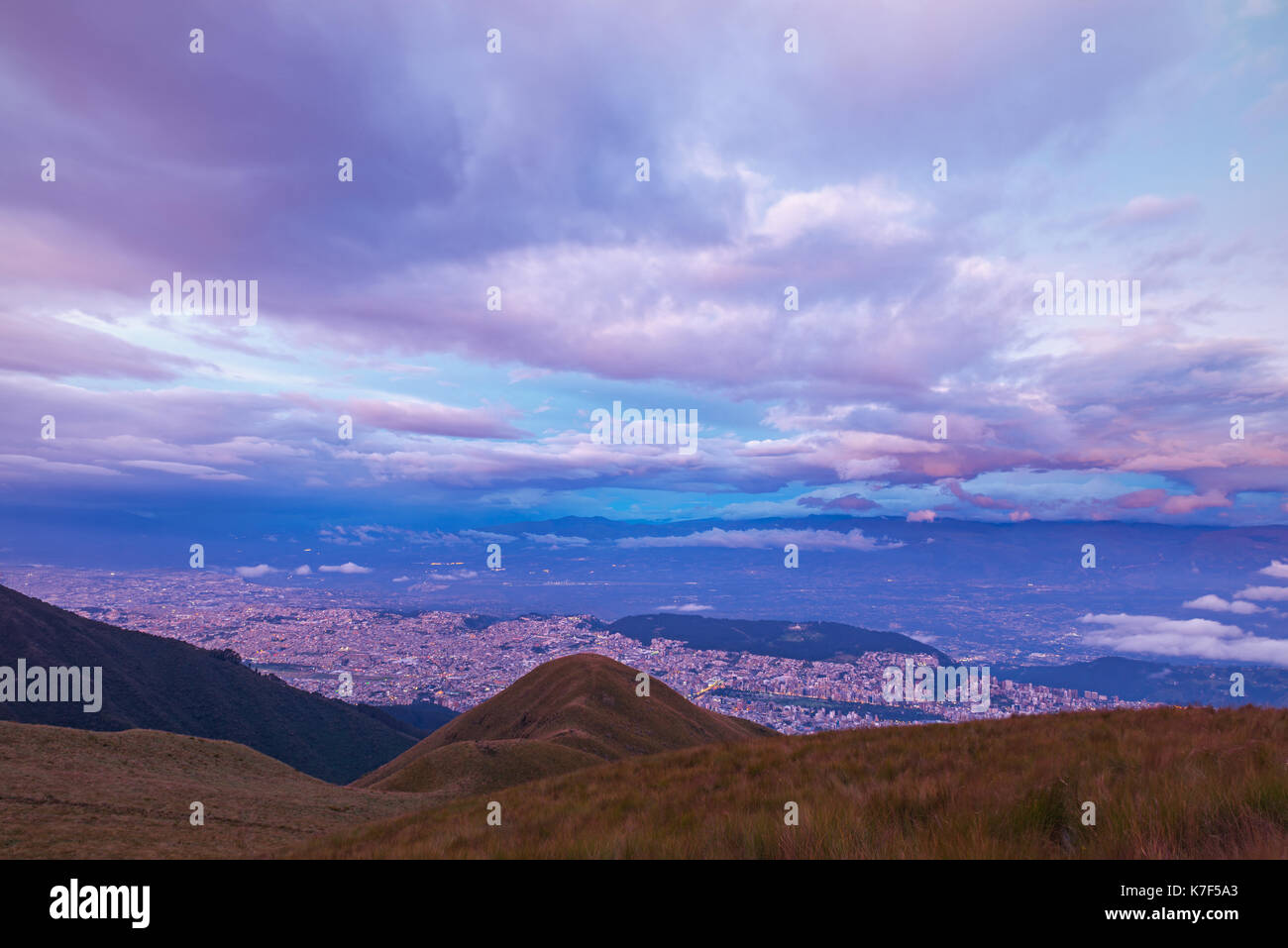 Die Skyline von Quito City bei Dämmerung mit einer langen Belichtungszeit und Luftaufnahme Foto aus dem aktiven Vulkan Pichincha, Ecuador, Lateinamerika gesehen. Stockfoto