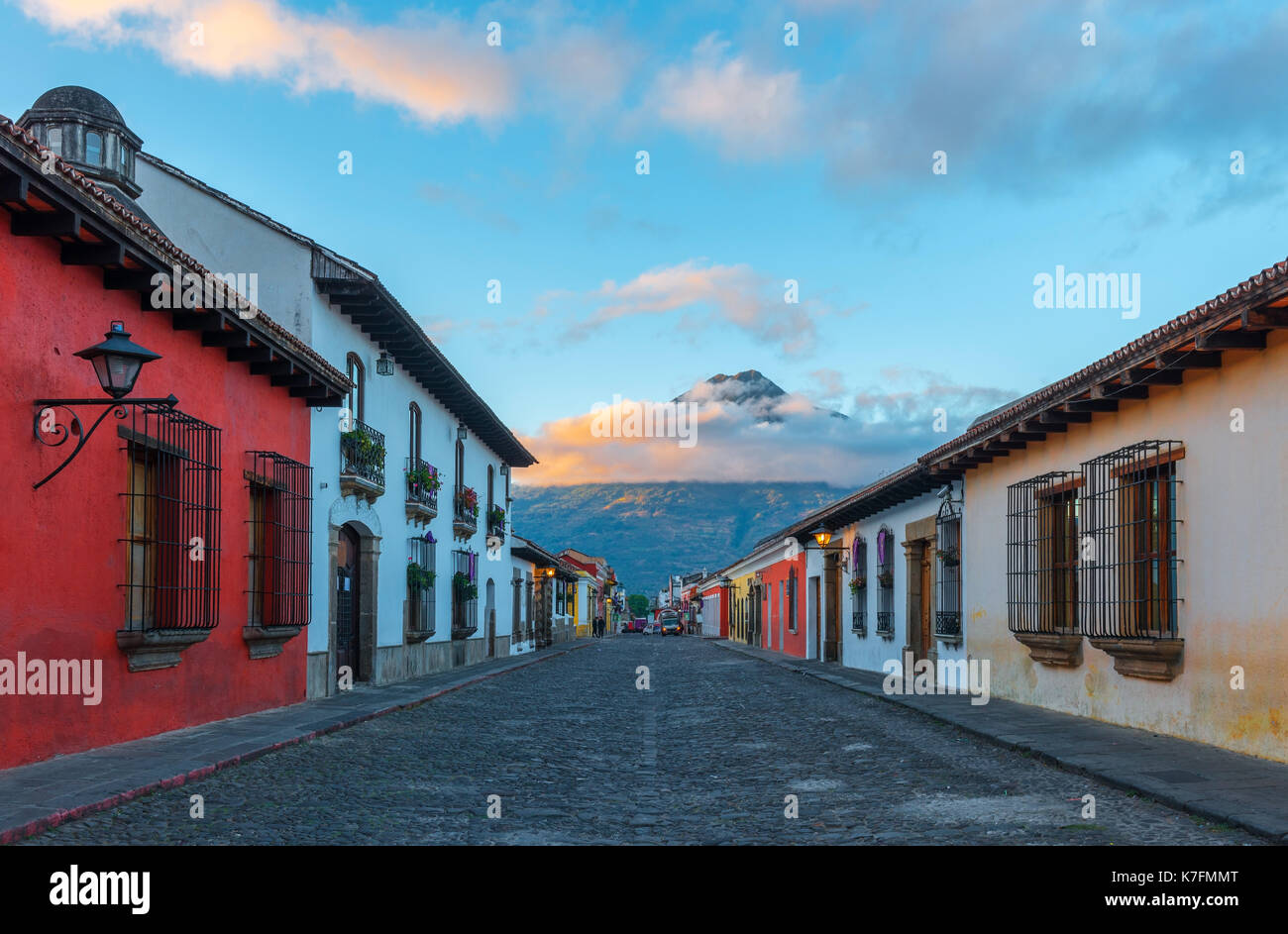 Eine bunte Straße bei Sonnenaufgang im historischen Zentrum von Antigua mit dem Agua Vulkan im Hintergrund, Guatemala, Mittelamerika. Stockfoto