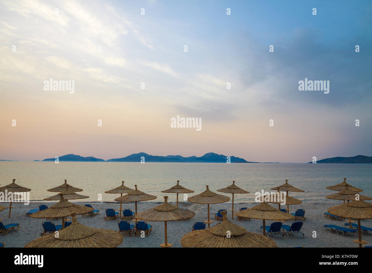 Zeile Liegen und Sonnenschirme am Strand am Morgen. Stockfoto