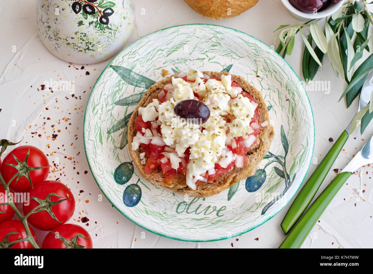 Dakos traditionelle Greekappetizer auf einem traditionellen Platte mit keramischen Olivenöl jar, trockenen Roggen Brot, Oliven und Olivenöl. Gesunde Ernährung Konzept. Mediterranen Lebensstil Stockfoto