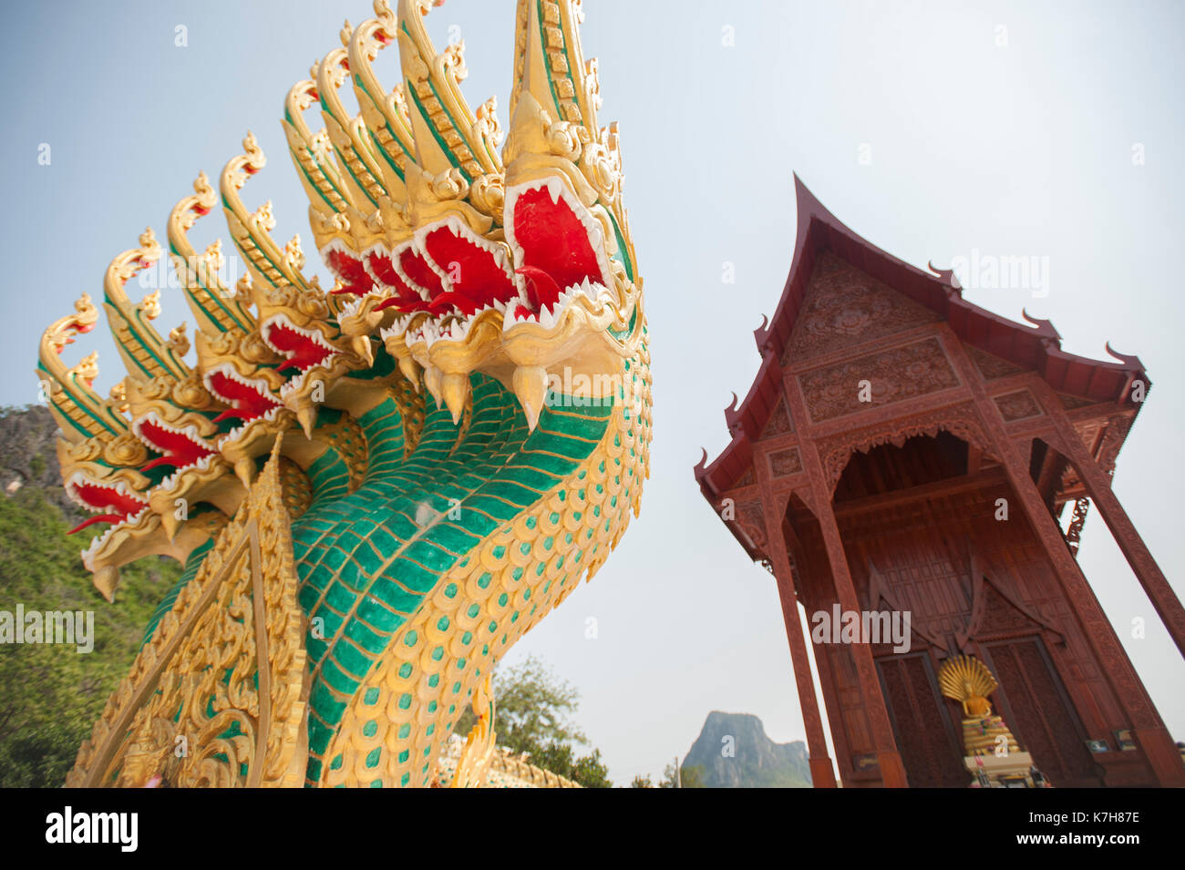 Grüne und goldene neunköpfige Naga schützt den Eingang des Teakholztempels Wat Ao Noi, Prachuap Khiri Khan, Thailand, Südostasien Stockfoto