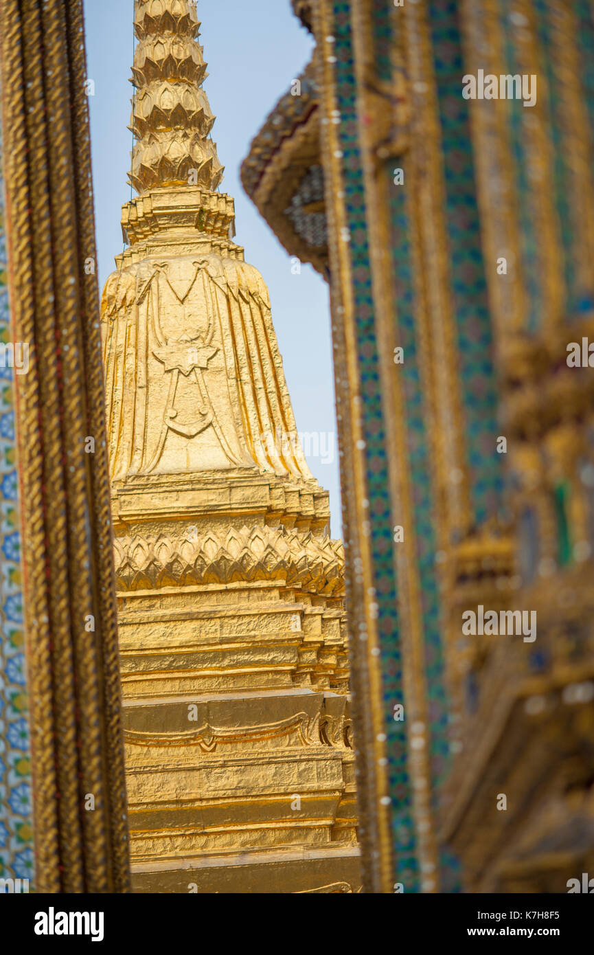 Wunderschöne verzierte Golden Chedi durch die kleine Lücke zwischen Phra Mondop und Prasat Phra Dhepbidorn im Wat Phra Kaew gesehen. Der Große Palast, Thailand Stockfoto