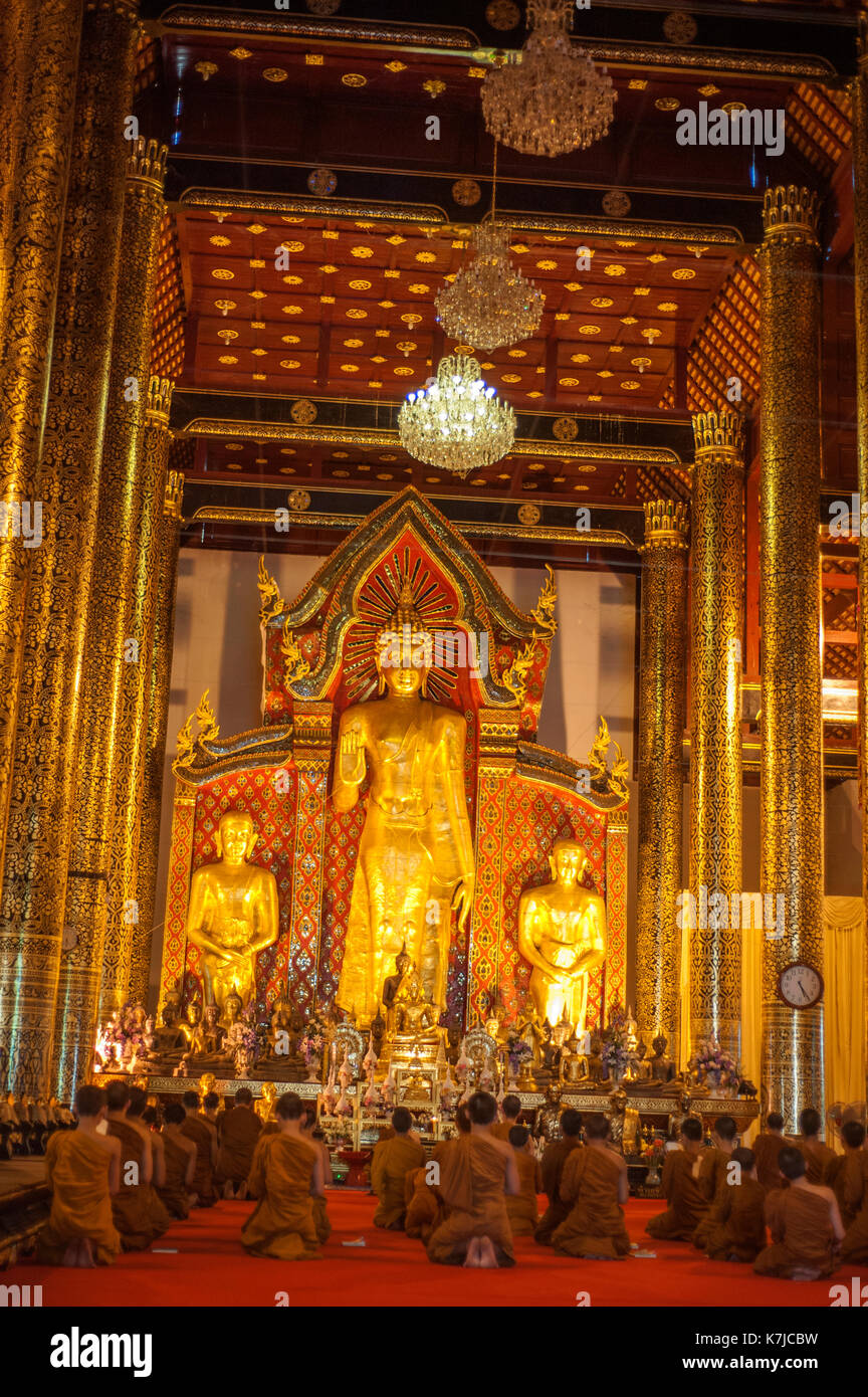 Mönche knien vor Buddha Statuen in den Wat Chedi Luang Tempel in Chiang Mai, Thailand Stockfoto