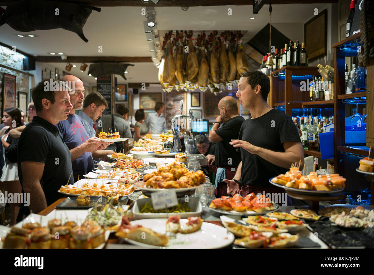 Diners und Personal im pintxos Tapas Bar Restaurant in San Sebastian, Donostia, im Baskenland, Spanien Stockfoto