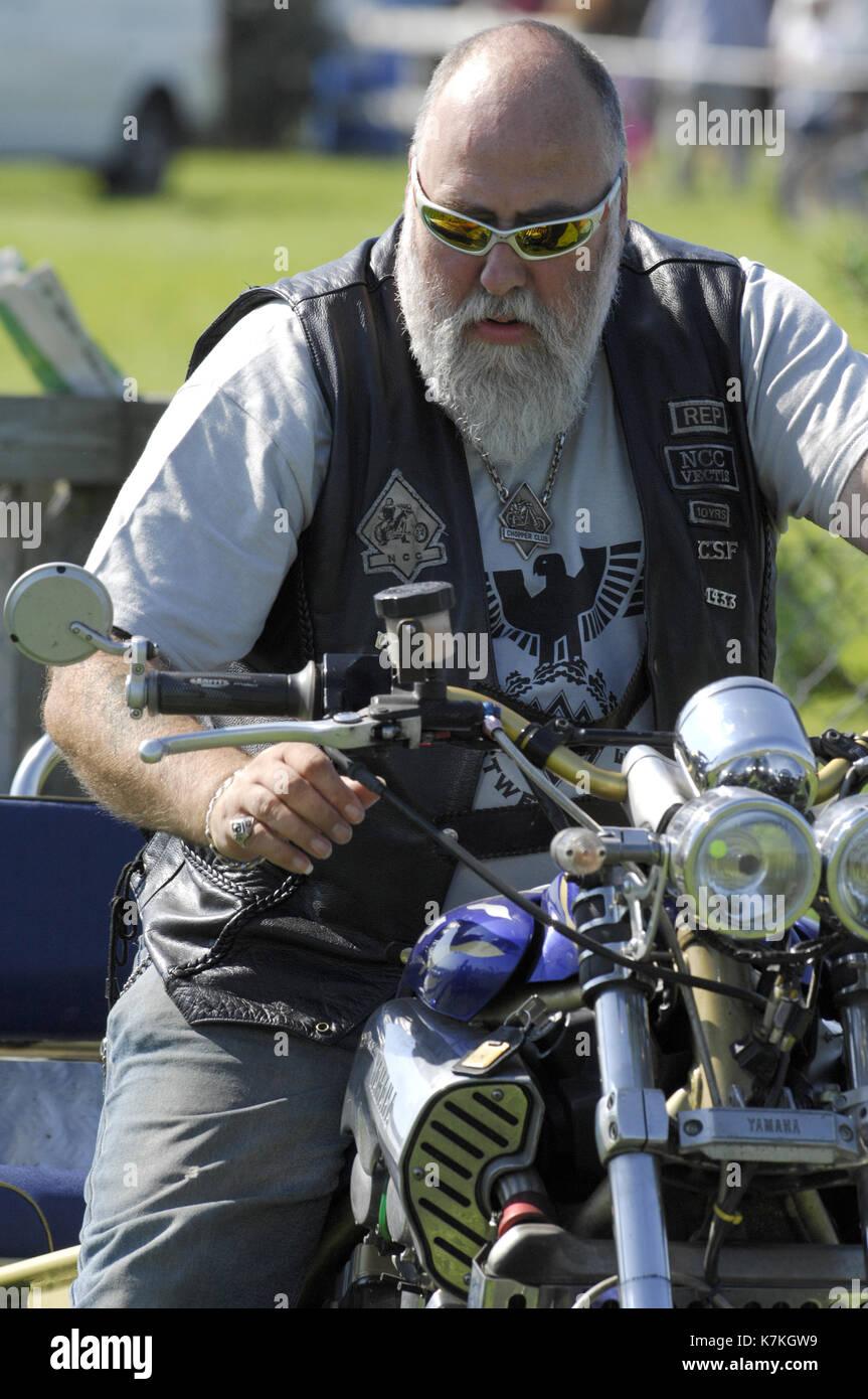 Eine haarige aggressive suchen Hells Angels Art der Biker auf einem  Motorrad mit einem grauen Bart und Brille suchen, und wütend. bike Motorrad  banden Stockfotografie - Alamy