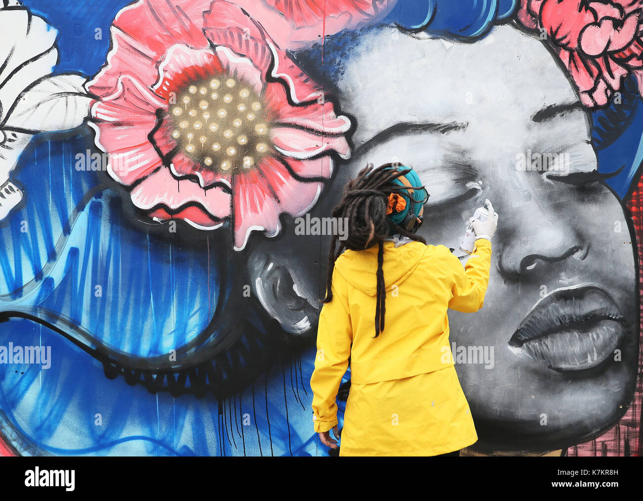 Street artist Kathrina Rupit aka Kinmx arbeitet nach dem "Frieden und Liebe Cube' während der BlueFire Straße fest in Smithfield, Dublin. Stockfoto