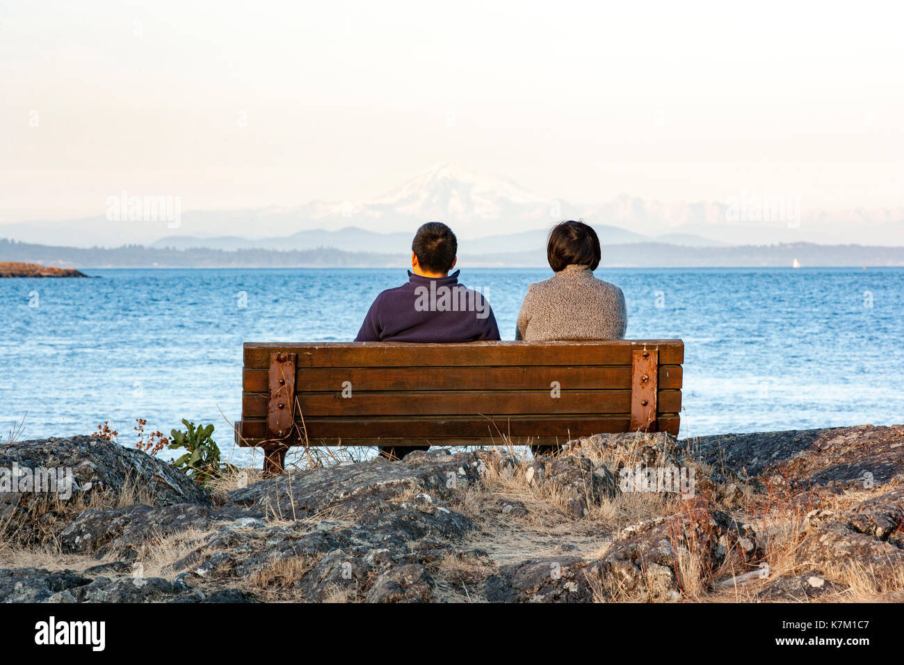 Pärchen auf Parkbank am Cattle Point, Uplands Park, Oak Bay, Victoria, Vancouver Island, British Columbia, Kanada Stockfoto