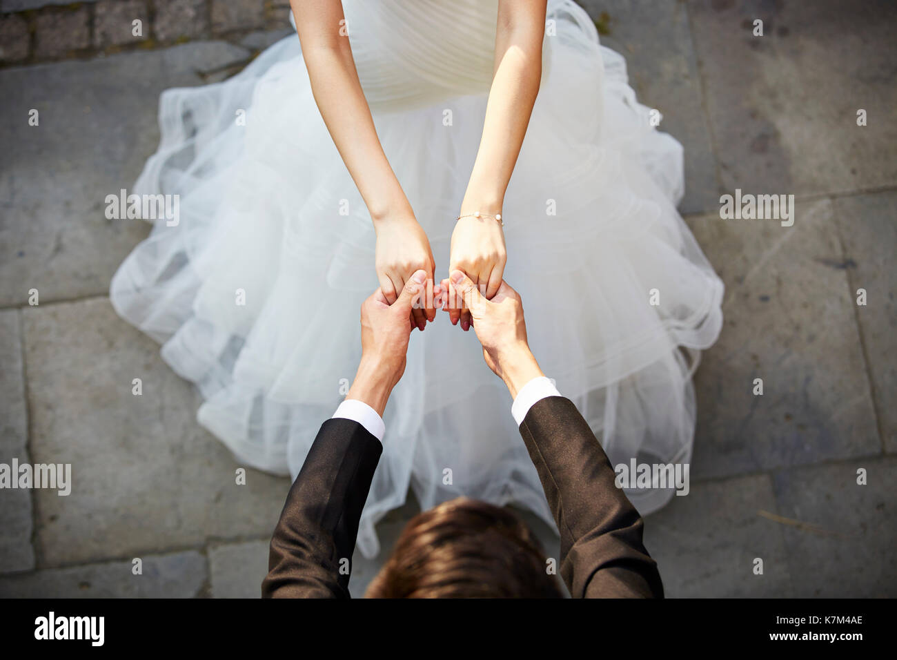 Junge asiatische Braut und Bräutigam halten sich an den Händen und Tanzen, hohe Blickwinkel betrachten. Stockfoto