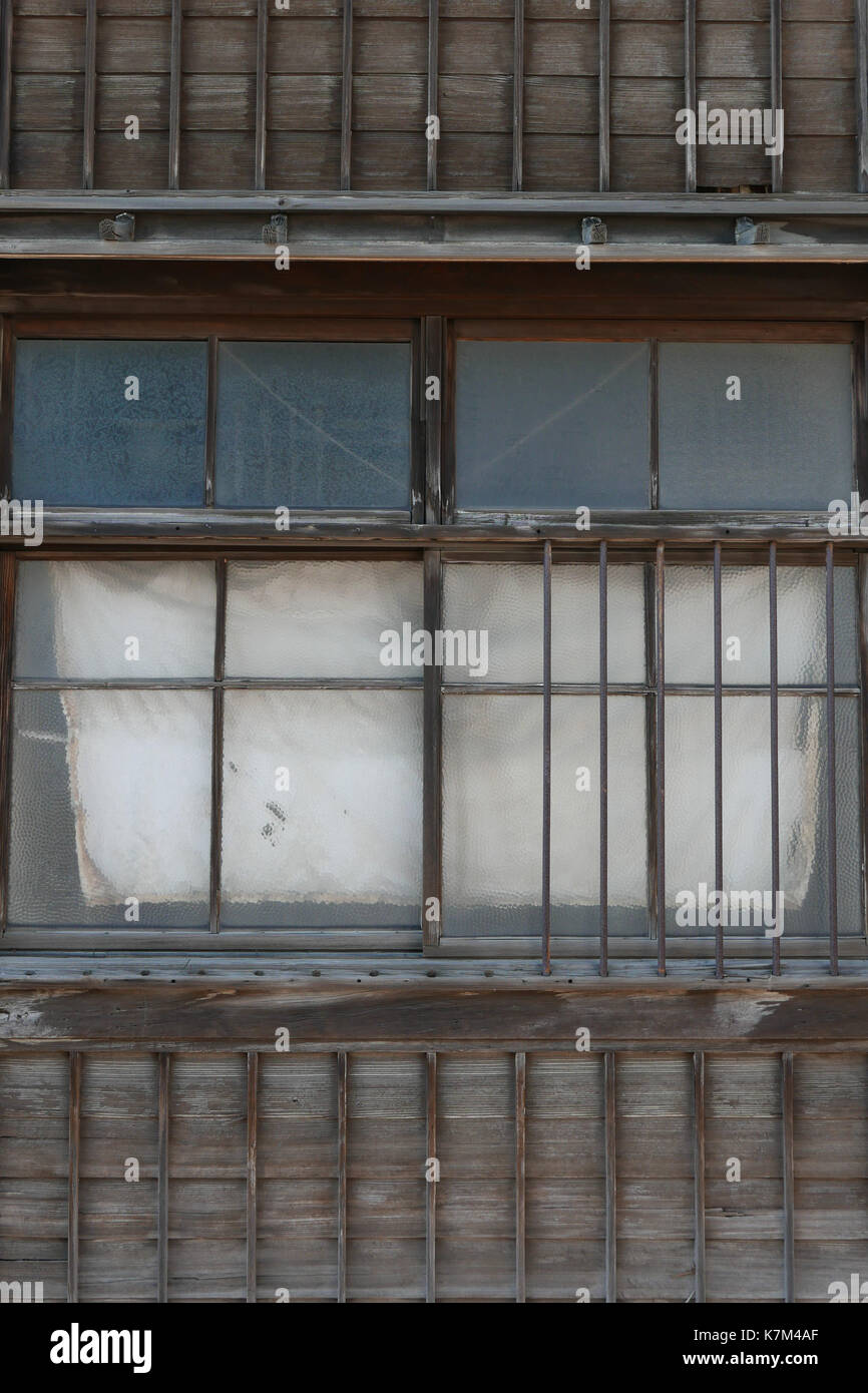 Traditionelle alte Holz und Bambus, mehrstöckiges Gebäude in Otaru Japan. Verwittert und verblasst Holz und Bambus lichtdurchlässiges Glas windows Bronze endkappen. Stockfoto