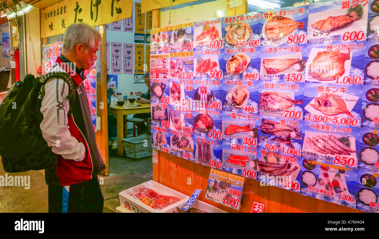 Japaner bei Sankaku Restaurant Menü Schild mit gekochten Fisch, Sashimi, Sushi suchen und Ausflüge außerhalb des Restaurants. Stockfoto