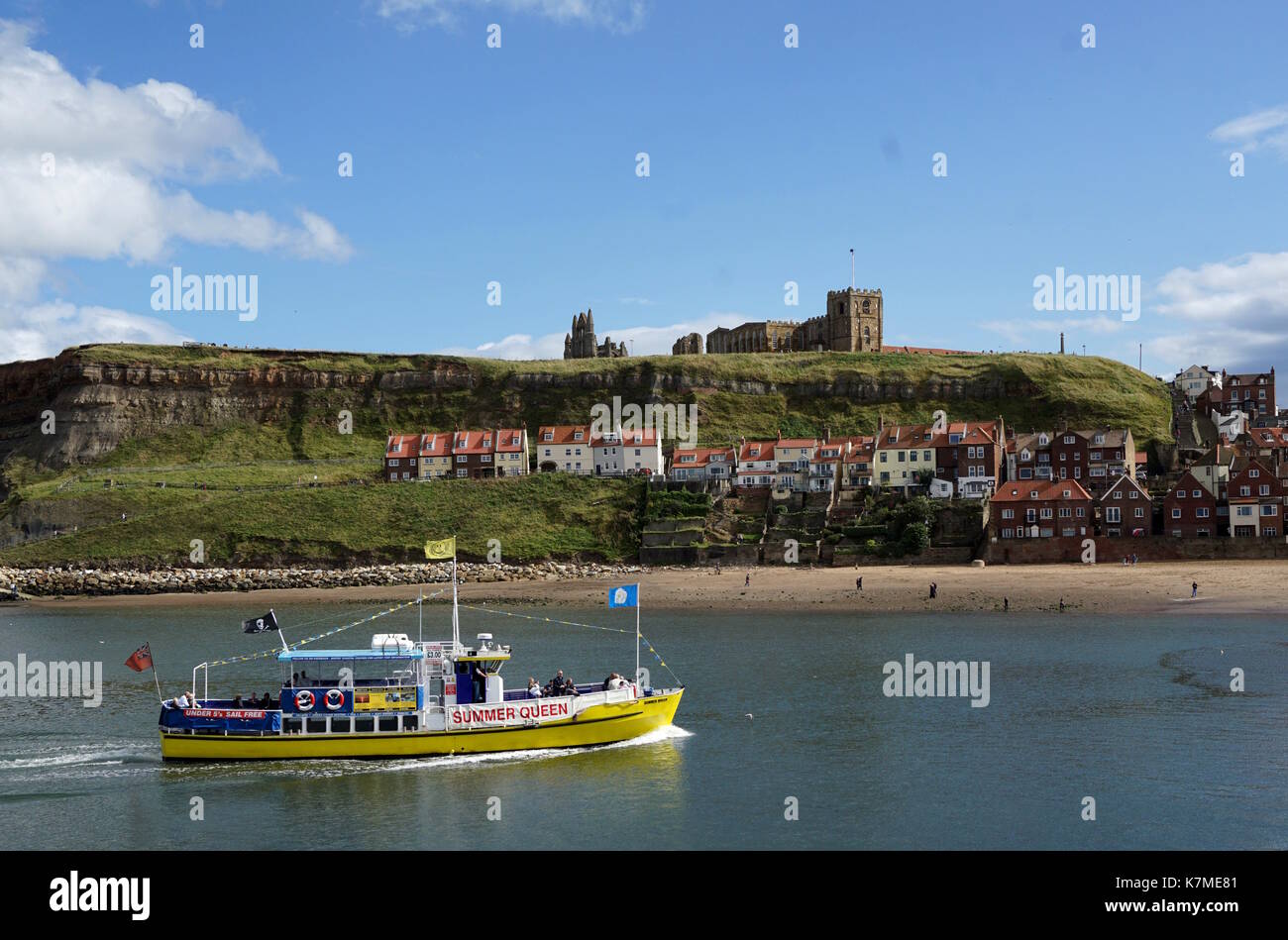 Tour Boot gleitet über einen reibungslosen Whitby Hafen. Stockfoto