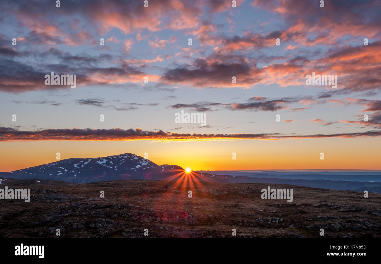 Sonnenstrahlen spänen bei Sonnenaufgang über den Bergen Stockfoto