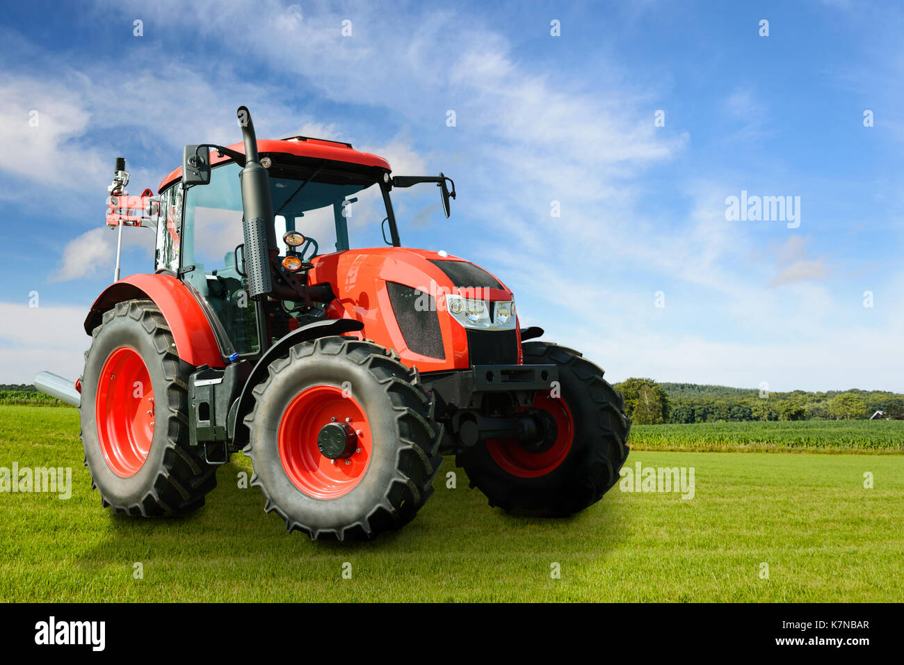 Das zusammengesetzte Bild eines modernen roten landwirtschaftlichen Generische Traktor auf einer grünen Wiese an einem sonnigen Tag. Mai darzustellen, Dritten IP. Stockfoto