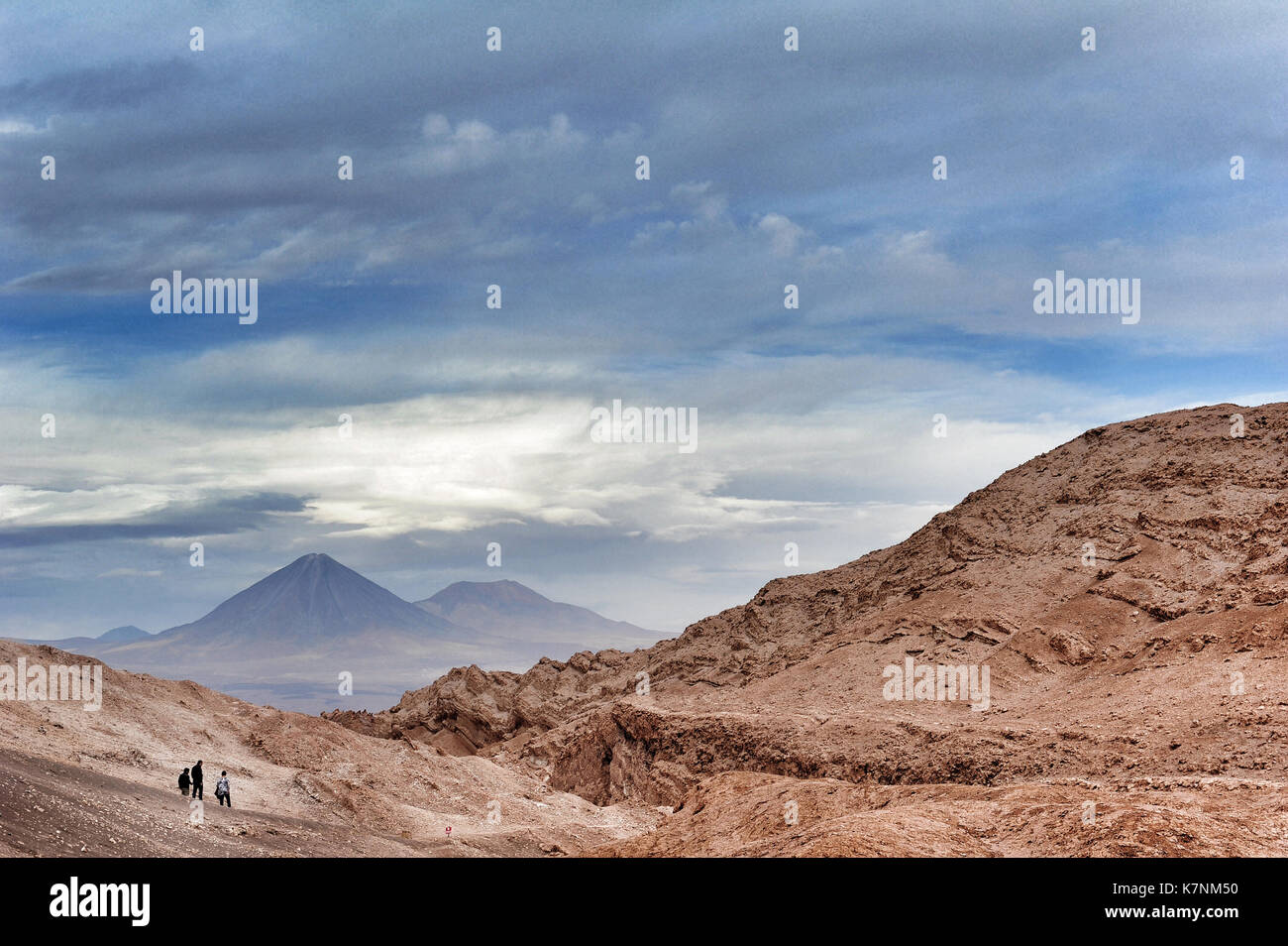 Drei Personen im Valle de la Luna, Chile. Im Hintergrund der Gipfel der Licancabur Vulkan. Stockfoto