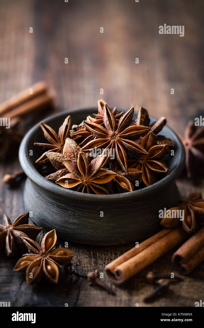 Anis Sterne in einem schwarzen Schüssel mit Zimtstangen und Nelken. Winter saison Backen konzept mit Platz für Ihren Text kopieren Stockfoto