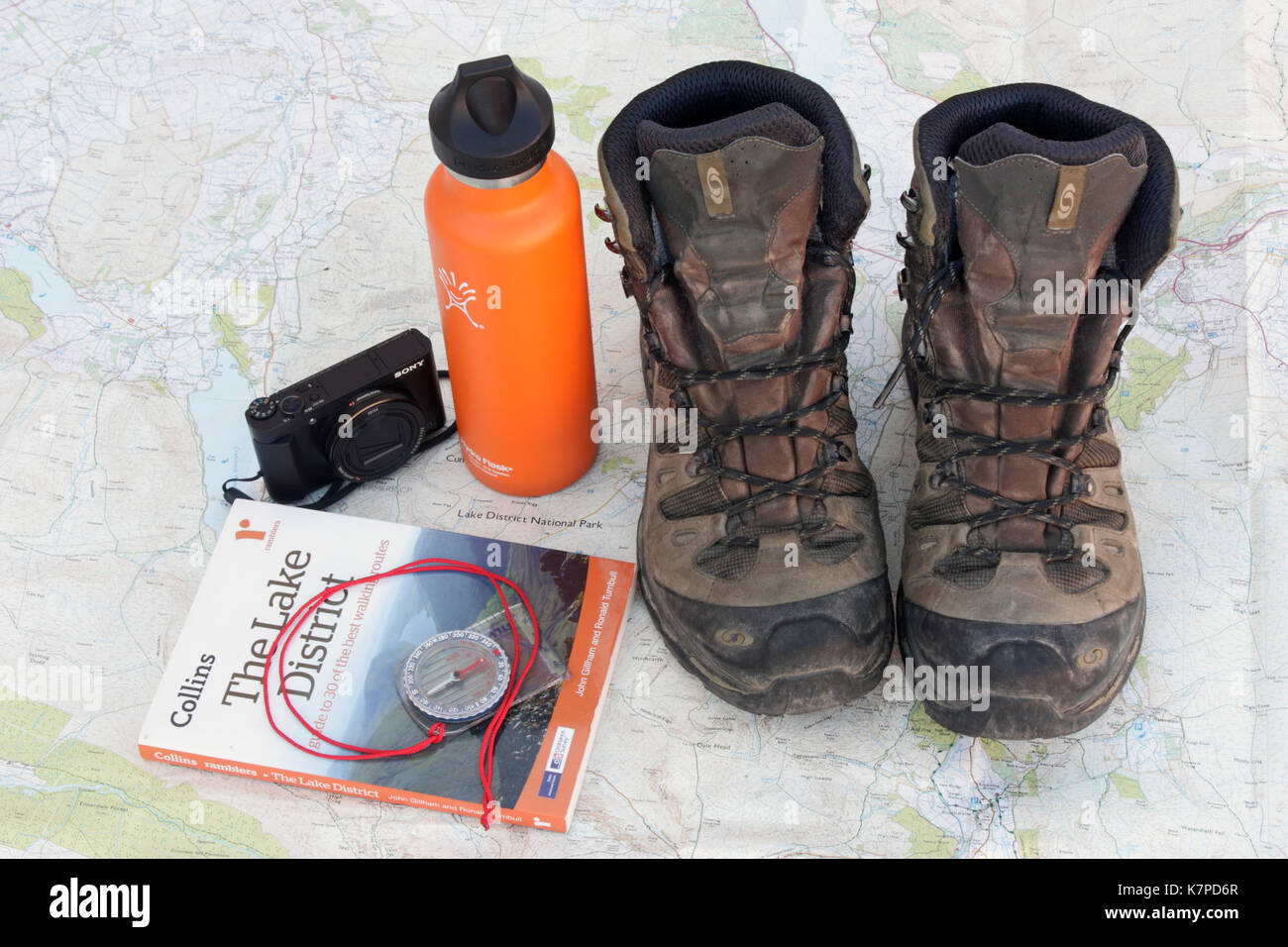 Vorbereitung für einen Wanderurlaub im Lake District. Wanderschuhe, wasser Kolben, Kamera, Ratgeber und Kompass auf einer Ordnance Survey Karte der Gegend Stockfoto