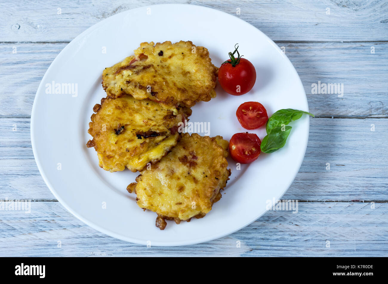 Koteletts und Cocktailtomaten. Teller auf eine weiße Platte. Vorderansicht. Stockfoto