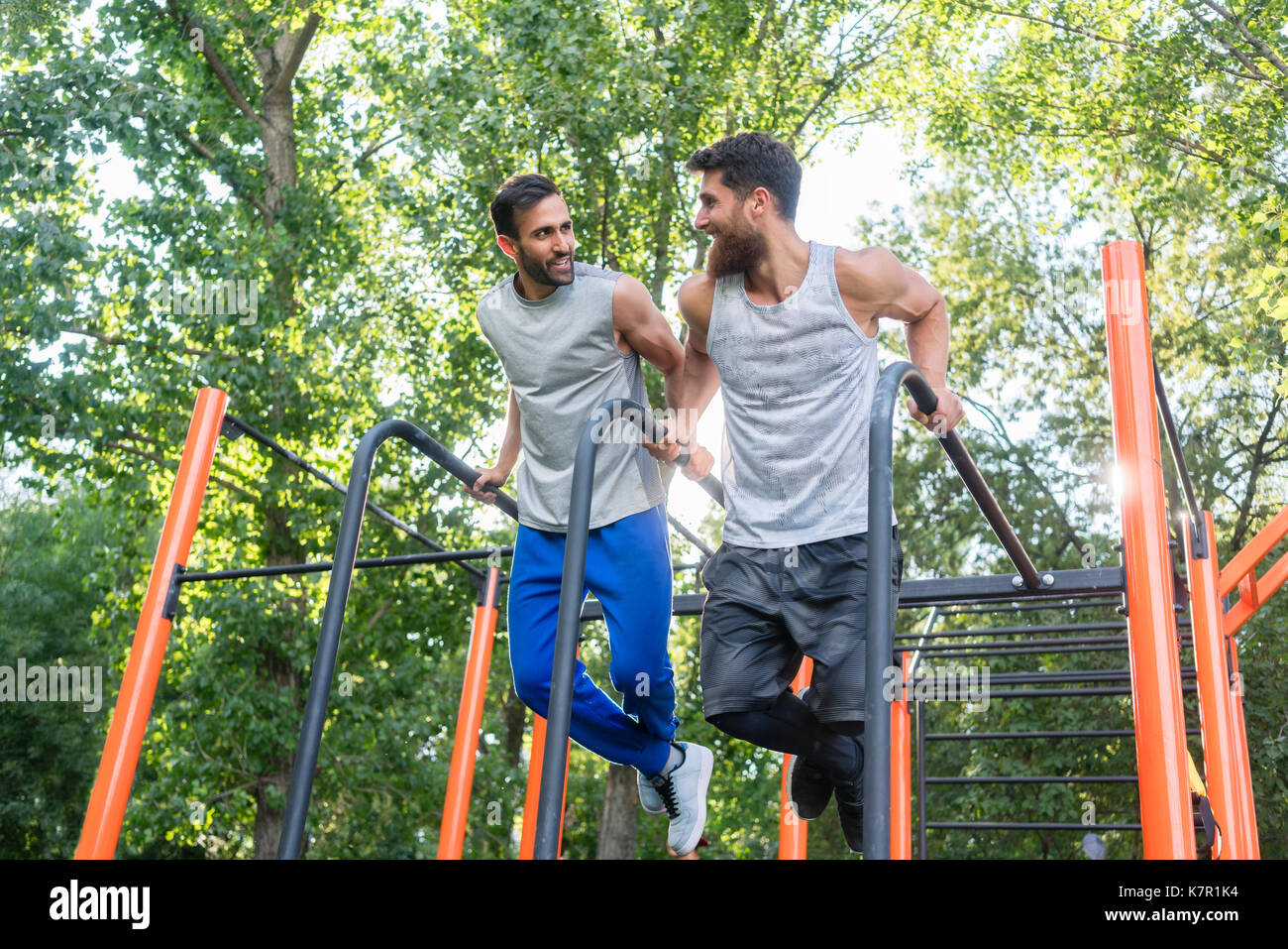 Zwei schöne junge Männer leidenschaftlich über Fitness dips Tun exerc Stockfoto