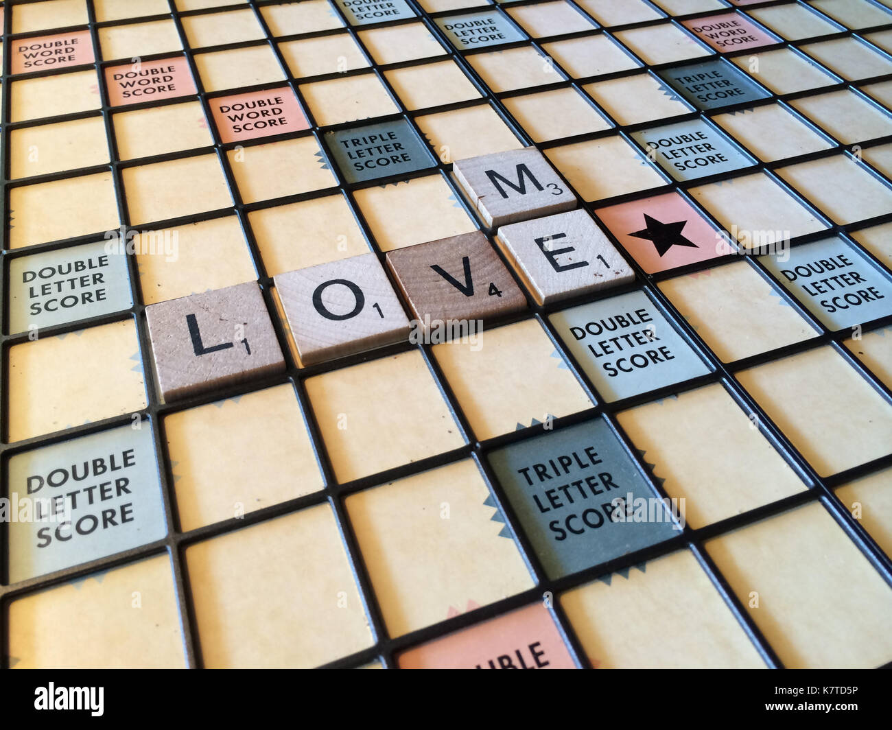 Die Worte "Liebe mich" heraus auf einem Scrabble Spiel Brett geschrieben Stockfoto