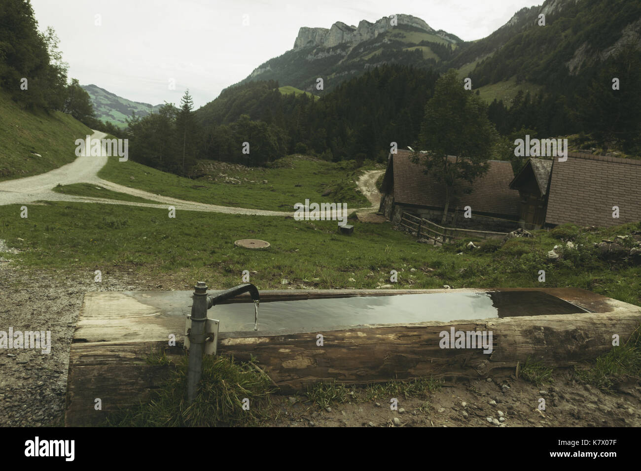 Holz- Brunnen vor der Wanderwege und Alpen Stockfoto