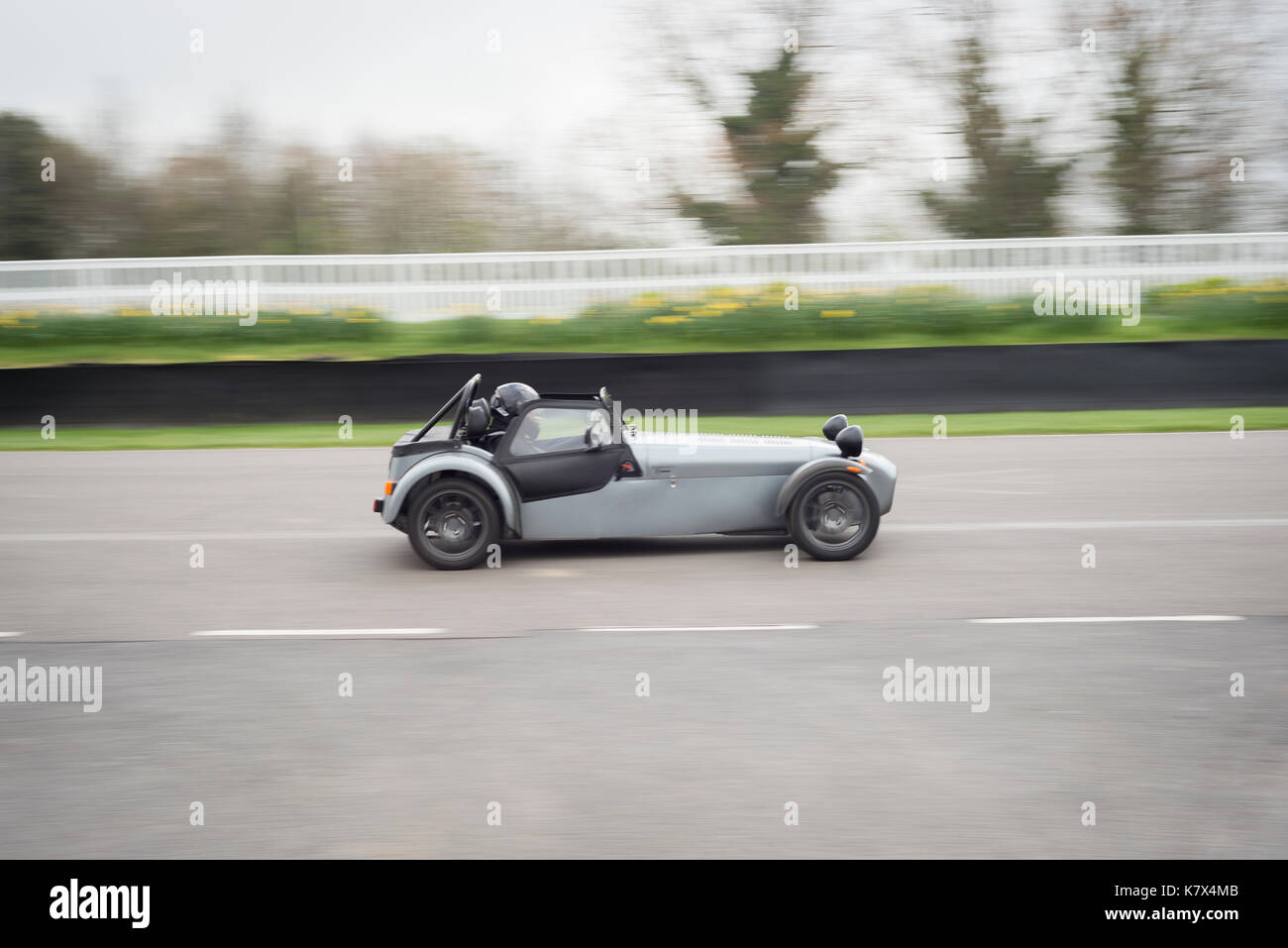 Schnelles Auto auf der Rennstrecke in Goodwood mit Bewegungsunschärfe Stockfoto