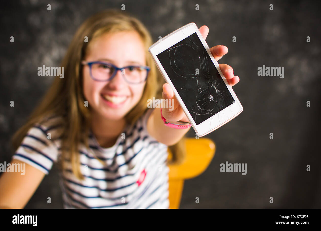 Mädchen zeigen ein Telefon mit Bildschirm und lächelnd Stockfoto