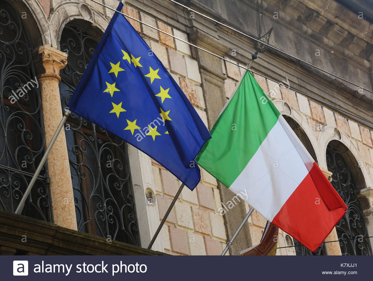 EU und italienische Flaggen nebeneinander außerhalb eines Verwaltungsgebäudes in Italien Stockfoto