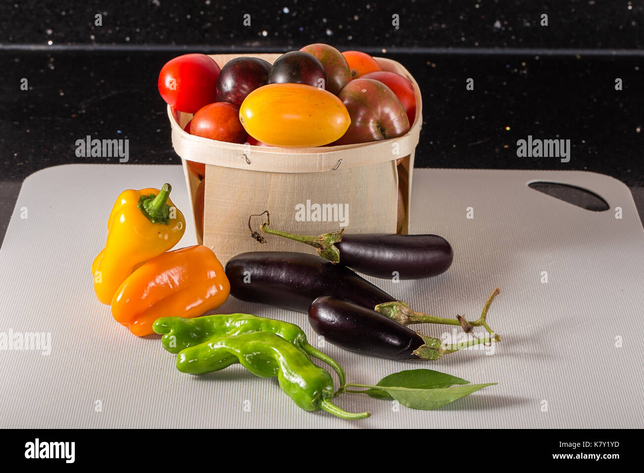 Frisch geerntete Tomaten, Sweet orange und grüne Paprika und Auberginen. Auf Zähler nach oben an Bord genommen. Stockfoto