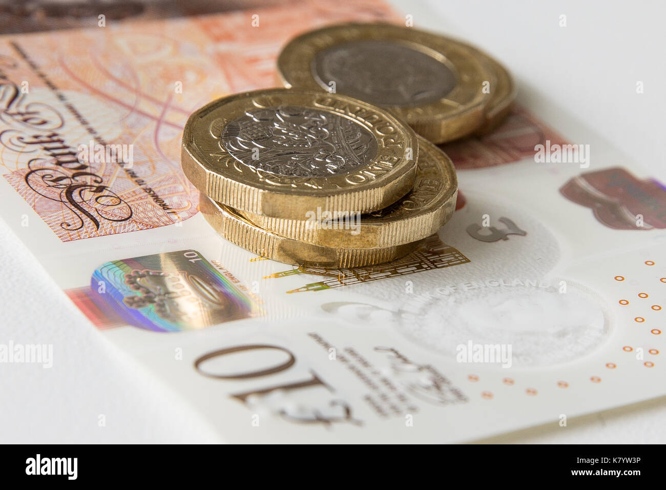 Bild des Neuen, Kunststoff, zehn Pfund Sterling, mit fünf Pfund Sterling Münzen auf seine Spitze. Stockfoto