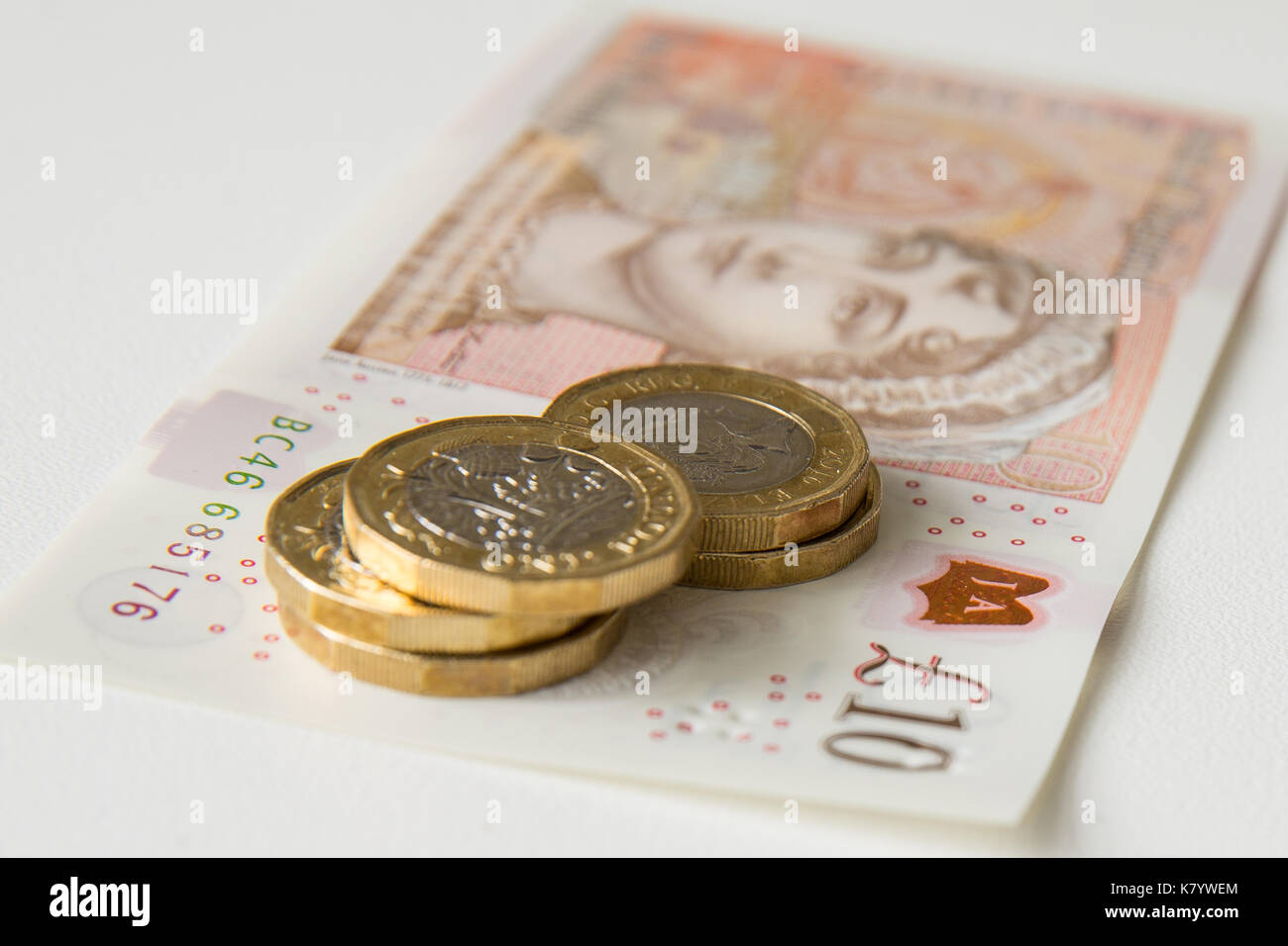 Bild des Neuen, Kunststoff, zehn Pfund Sterling, mit fünf Pfund Sterling Münzen auf seine Spitze. Stockfoto