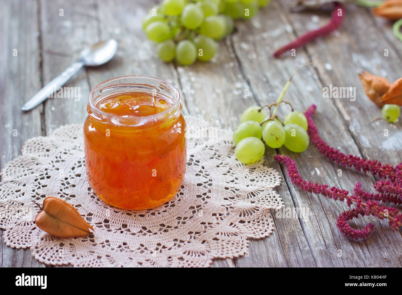 Slatko erhaltenen weißen Trauben in Glas, Holz- Hintergrund; traditionelle serbische Wüste aus weißen Trauben oder weiße Kirschen Stockfoto
