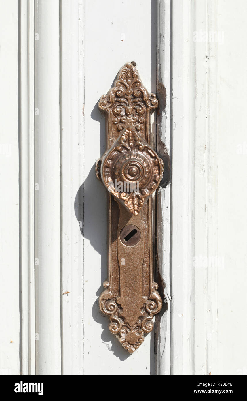 Alte Bronze türgriff auf einem weißen alte Tür Stockfoto