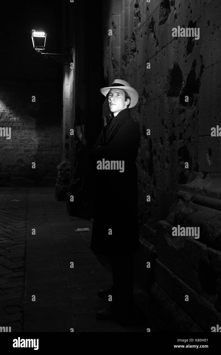 Schwarz-weiß Film noir Bild des Menschen stehen und warten im Lampenlicht Stockfoto