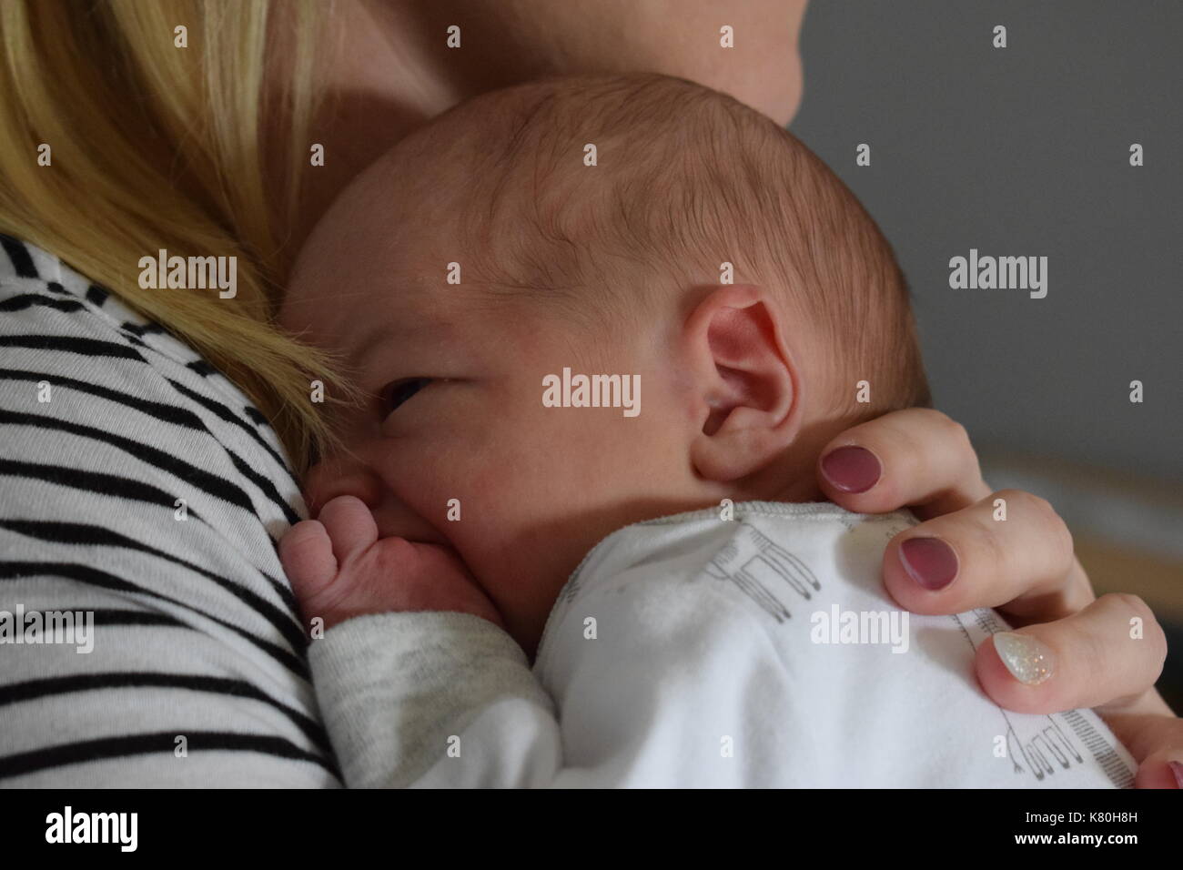 New Born Baby Boy cuddles mit seiner Mutter Stockfoto