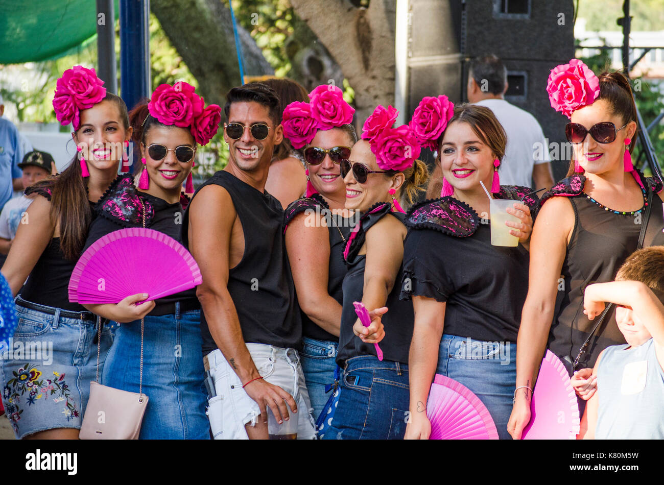 Gruppe von Frauen und einem Mann, Freunde, die während der Feria-Feierlichkeiten im spanischen Dorf Mijas, Spanien posieren. Stockfoto
