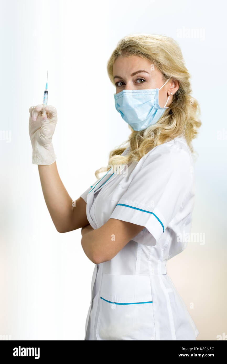 Junge Krankenschwester in der Maske holding Spritze. Stockfoto