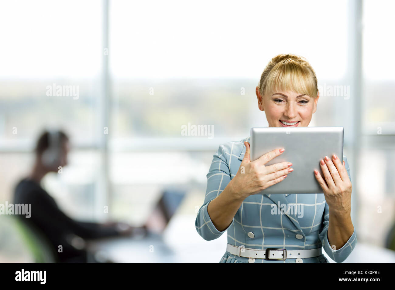 Reife Frau lächelnd mit digitalen Tablet. Stockfoto