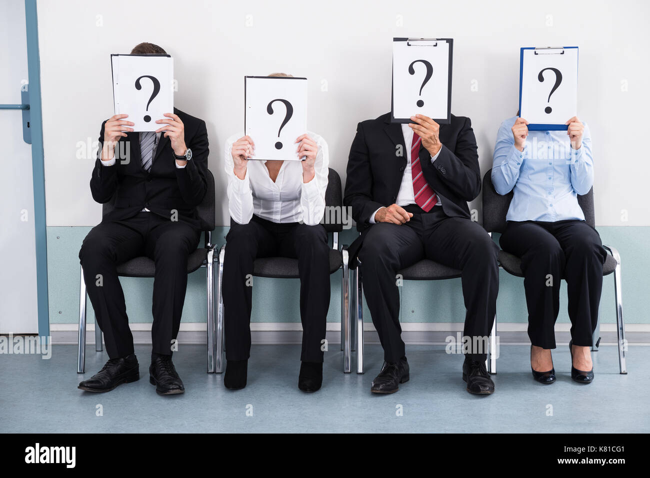 Geschäftsleute sitzen auf Stuhl versteckt sich hinter Fragezeichen Zeichen Stockfoto