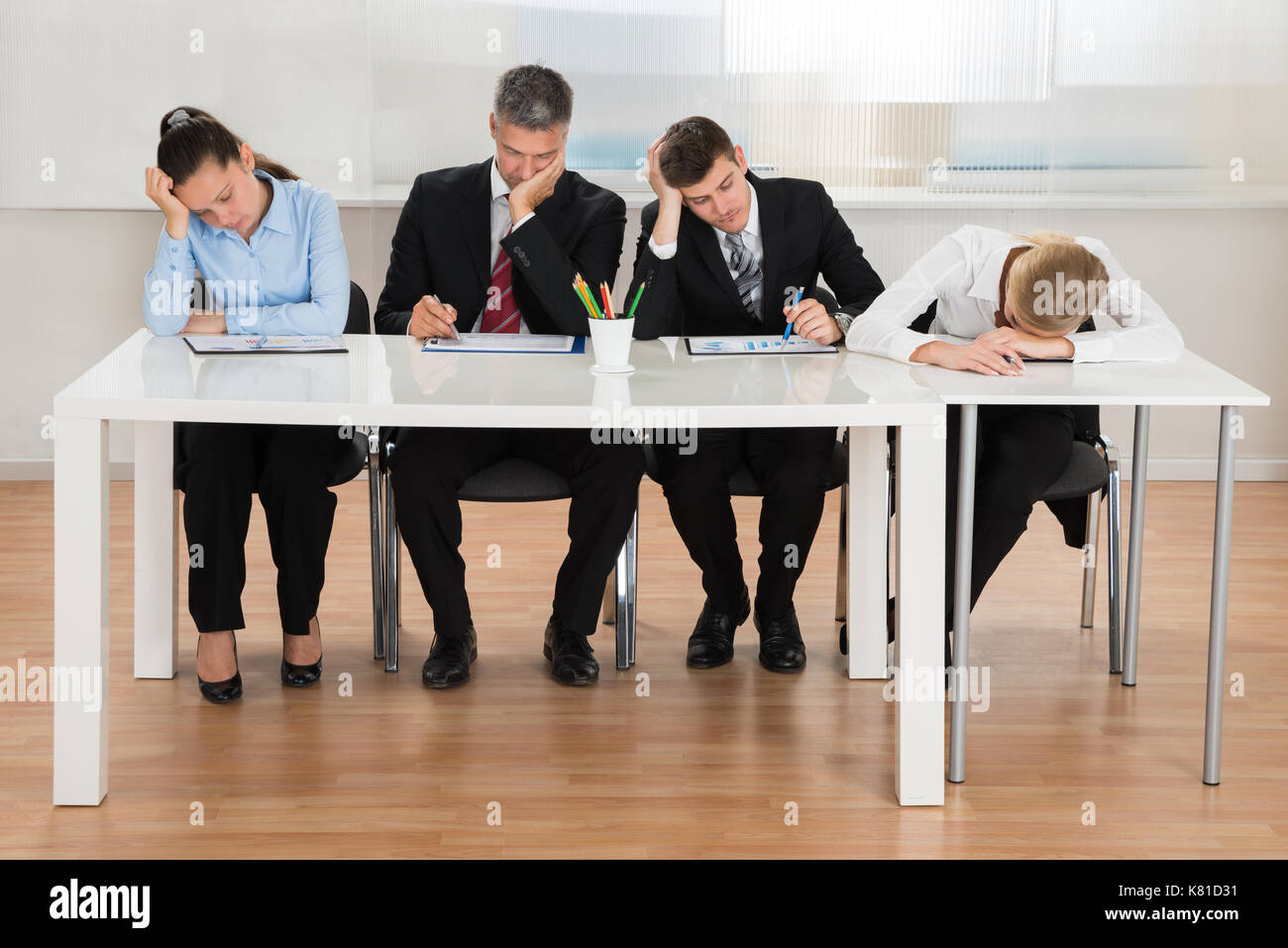 Mannschaft der Geschäftsleute, die sich während der Arbeit am Schreibtisch im Büro langweilen Stockfoto