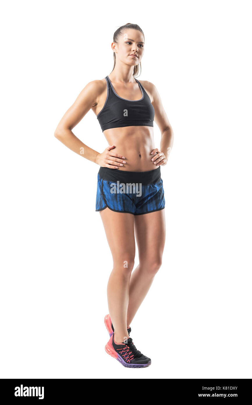 Zuversichtlich fitness sportliche Frau mit Händen auf den Hüften weg schauen. Voller Körper Länge Porträt auf weißem studio Hintergrund isoliert. Stockfoto