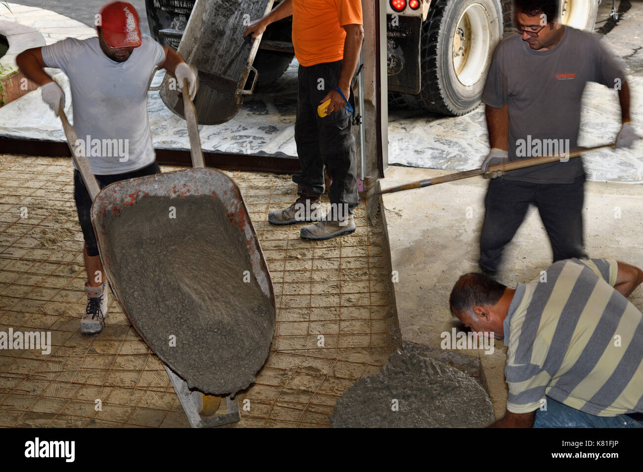 Arbeit Mannschaft Zement von einem betonmisch-Lkw von schubkarre über Drahtgeflecht auf ein Wohngebiet garage Boden auszubreiten Stockfoto