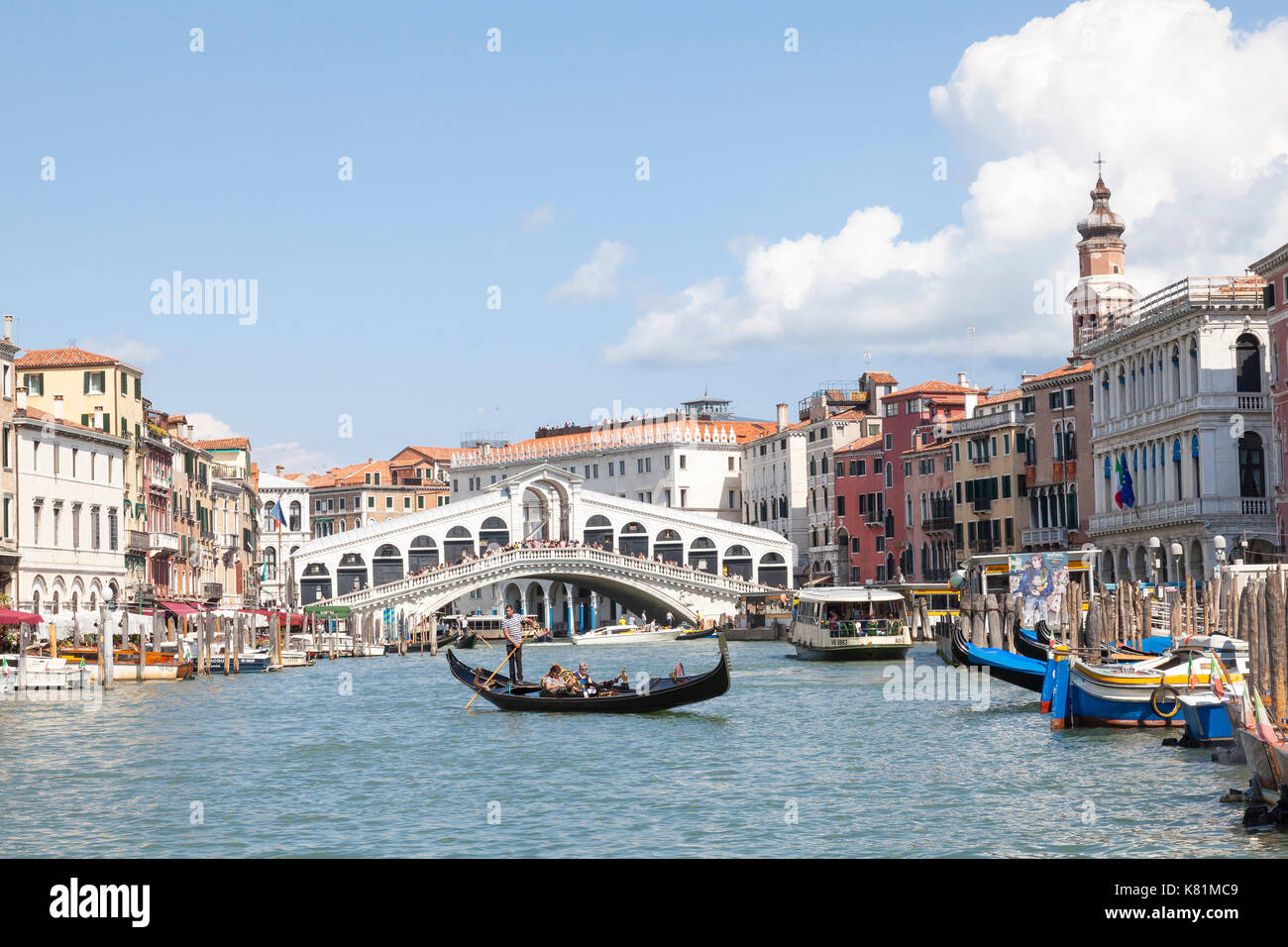 Rialto Brücke, Grand Canal, San Marco, Venedig, Venetien, Italien mit einer Gondel im Vordergrund und cumulus Wolken im blauen Himmel nach einem Sturm Stockfoto