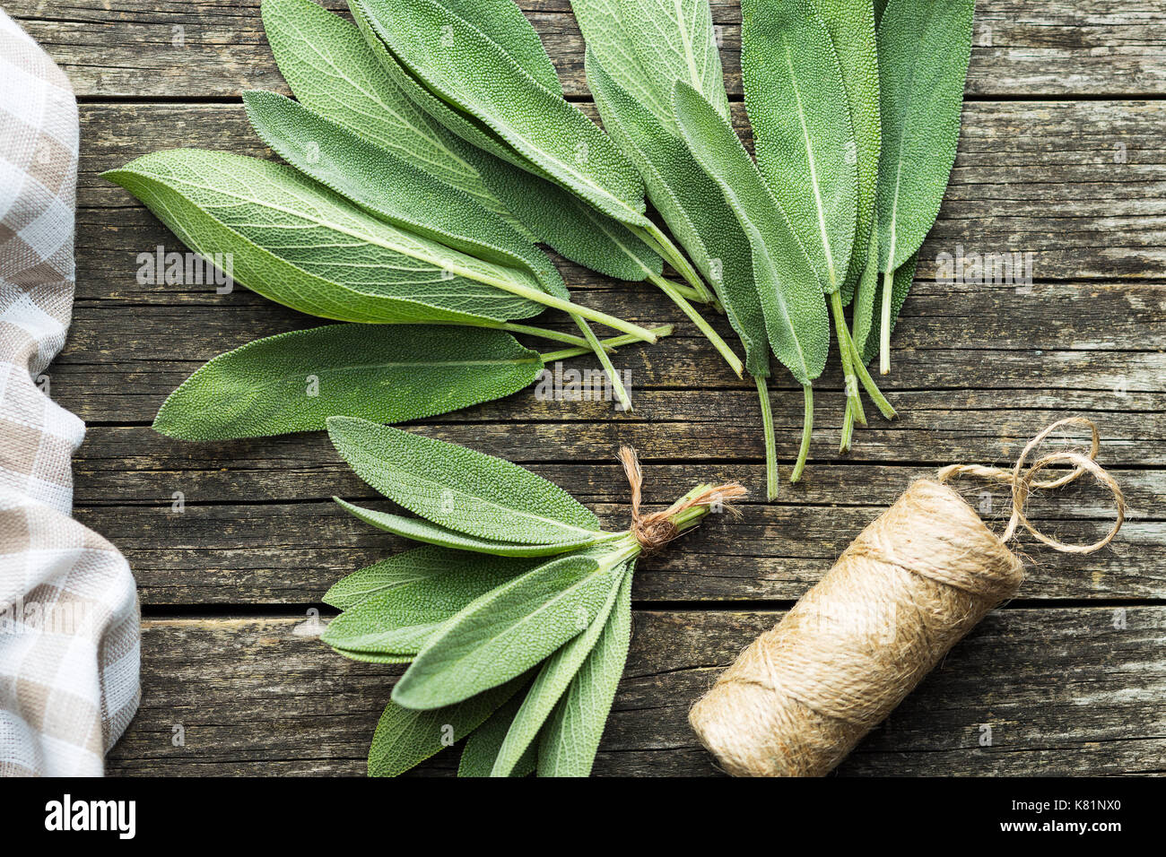 Salvia officinalis. Salbeiblätter auf alten Holztisch. Garten Salbei. Stockfoto