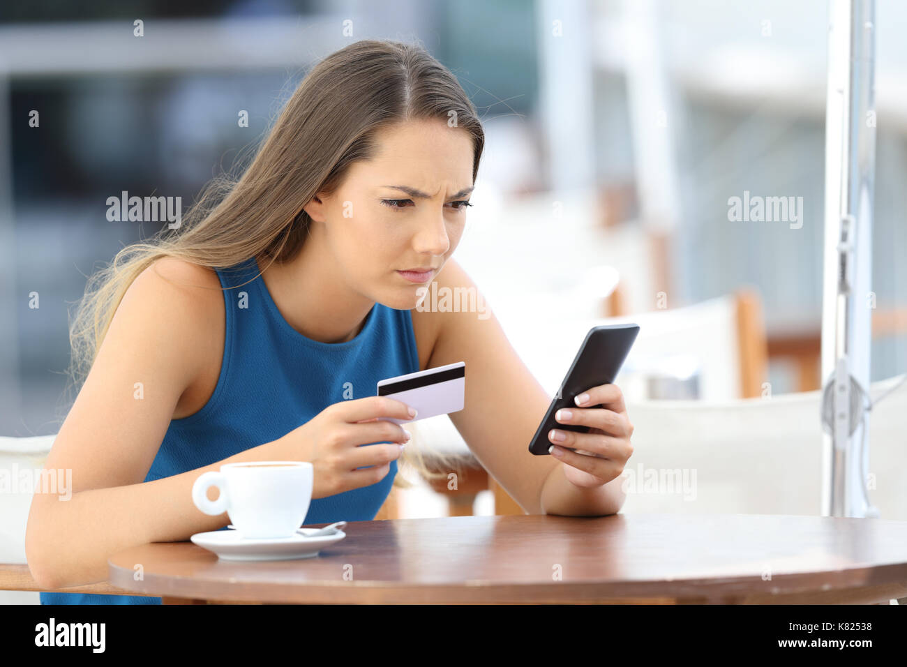 Single besorgt Mädchen Probleme mit der Bezahlung Online mit Kreditkarte und einer Telefonnummer in einem Café Terrasse Stockfoto